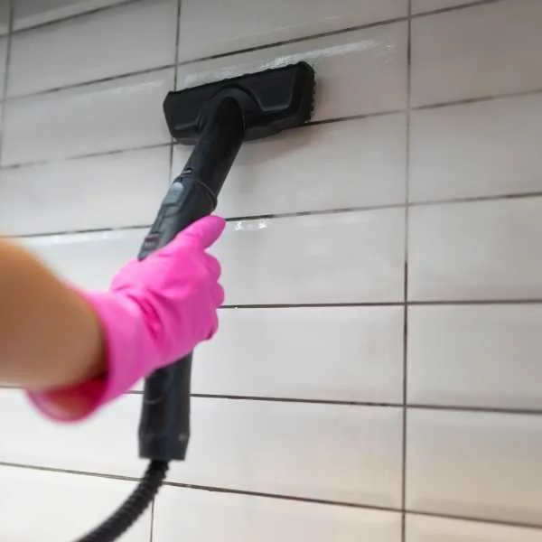 Steam cleaning grout in tile wall