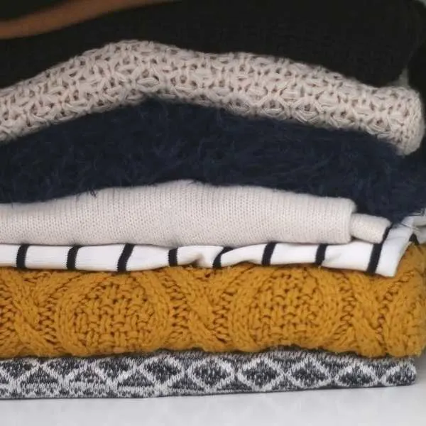 Folded sweaters on a shelf