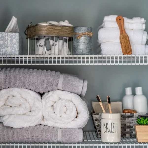 Towels, toothbrushes and other items on a bathroom shelf