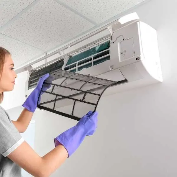 A woman cleaning air conditioner filter