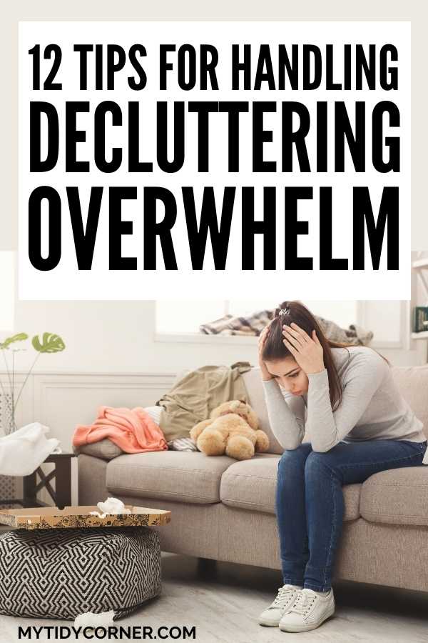Woman with hands on her head sitting down in a cluttered room with text that says, "How to handle decluttering overwhelm".
