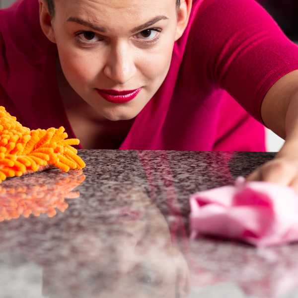 A woman cleaning a granite counter