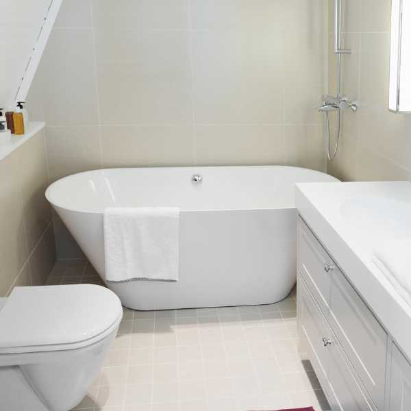 A small Bathroom with white tub and toilet
