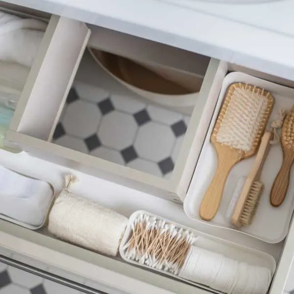 Hair brushes, q-tips and other items in a bathroom cabinet.