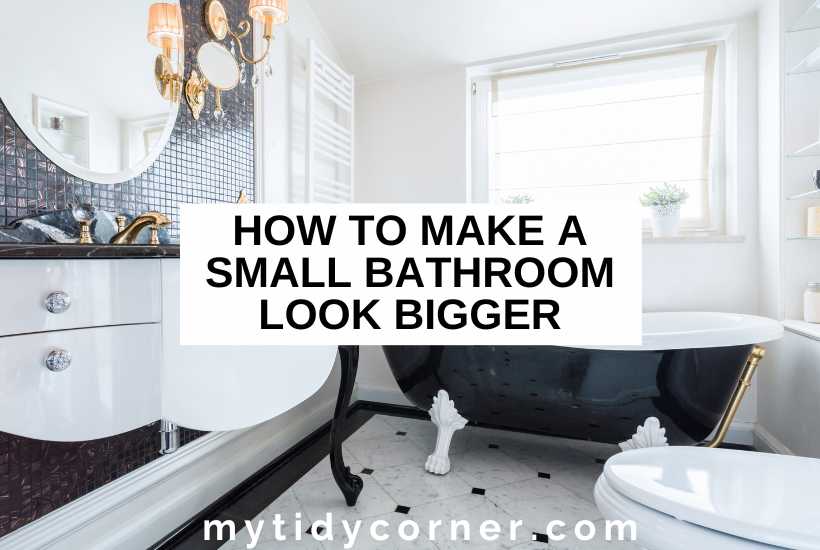 Black bathtub, cabinet in a bathroom and text overlay that reads, "How to make a small bathroom look bigger".