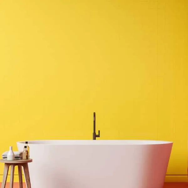 White tub in front of a yellow wall.