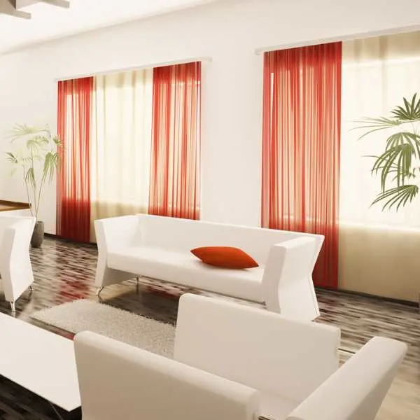 A modern room with burnt red curtains,