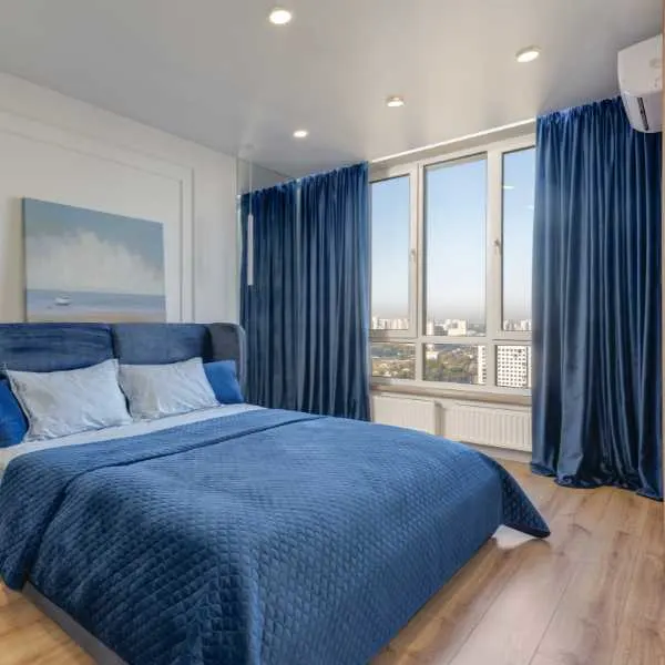 Bedroom with blue curtains and blue bedding.