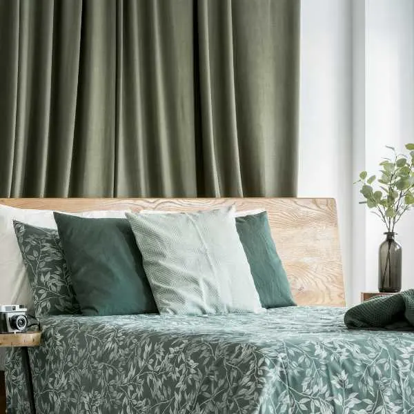 Bedroom with earthy green curtains.