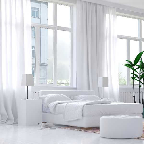 Modern bedroom with white sheer curtains.