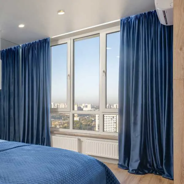 Bedroom with rich blue curtains.