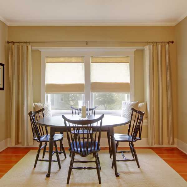 Dining room with beige walls and curtains.