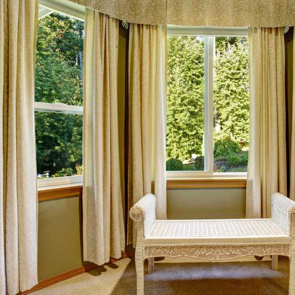 Room with green walls and cream curtains.