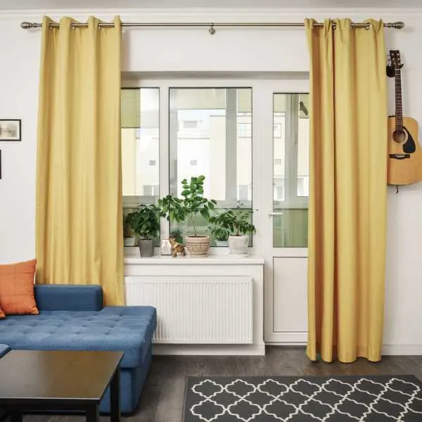Room with white walls and yellow curtains.