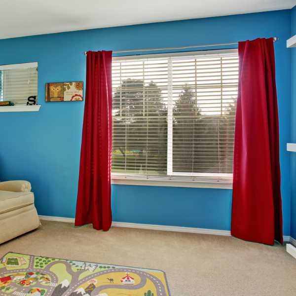 Room with blue walls and red curtains.