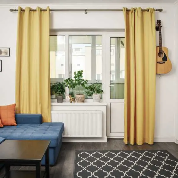 Room with full length yellow curtains.