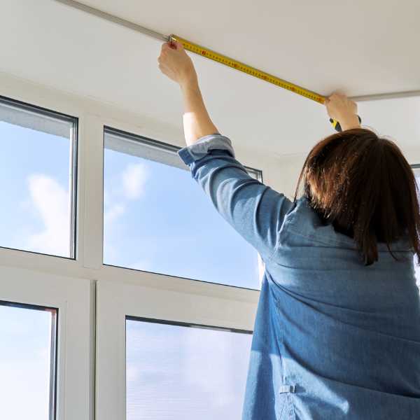Woman measuring window width.