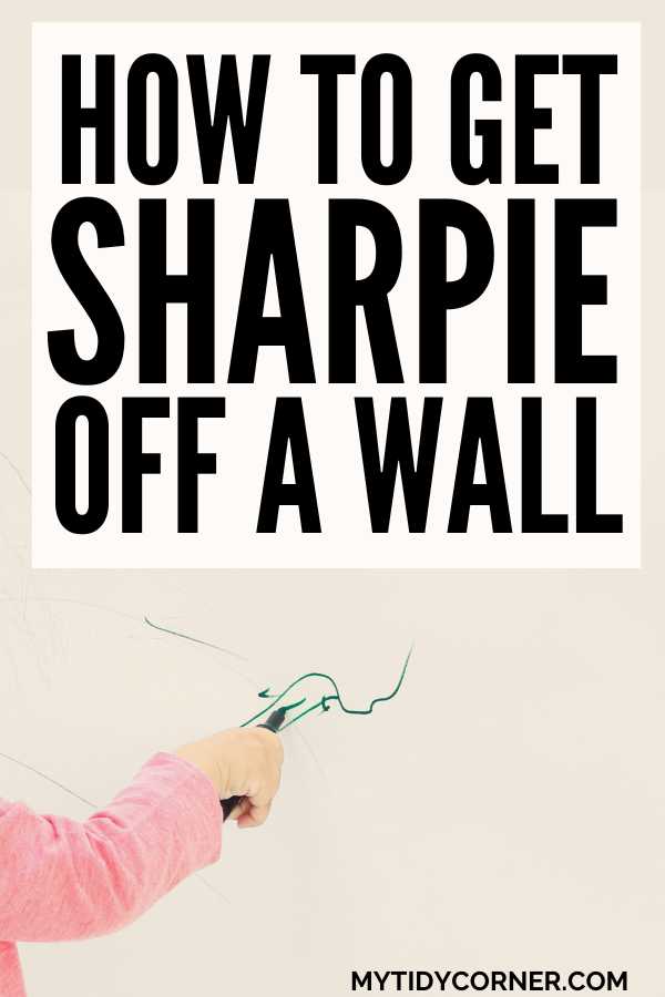 Hand writing with a market on the wall and text overlay that reads, "How to get Sharpie off a wall".
