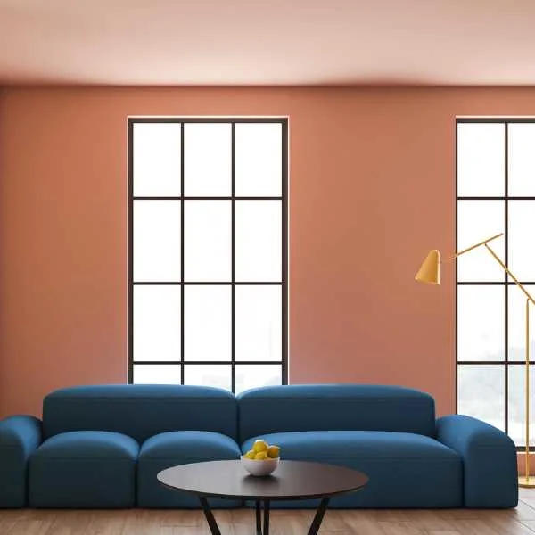 Living room with beige wall, blush ceiling and blue couch.