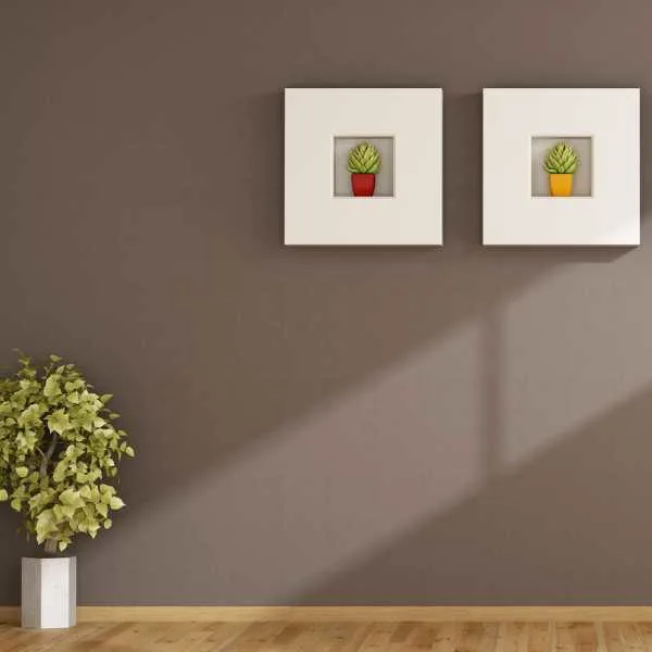 Room with chocolate brown wall, plant and wall arts.