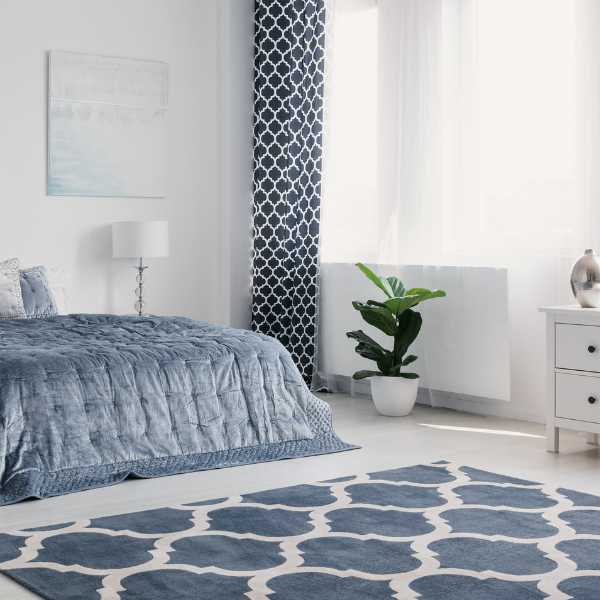 Blue bedroom with patterned rug.