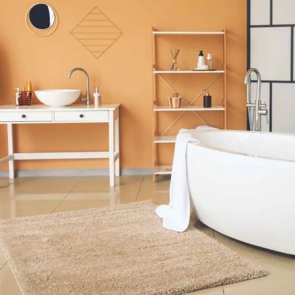 Interior of stylish bathroom with beige rug.