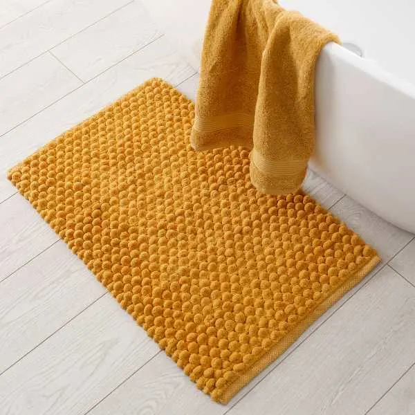 Orange rug and towel in a bathroom.