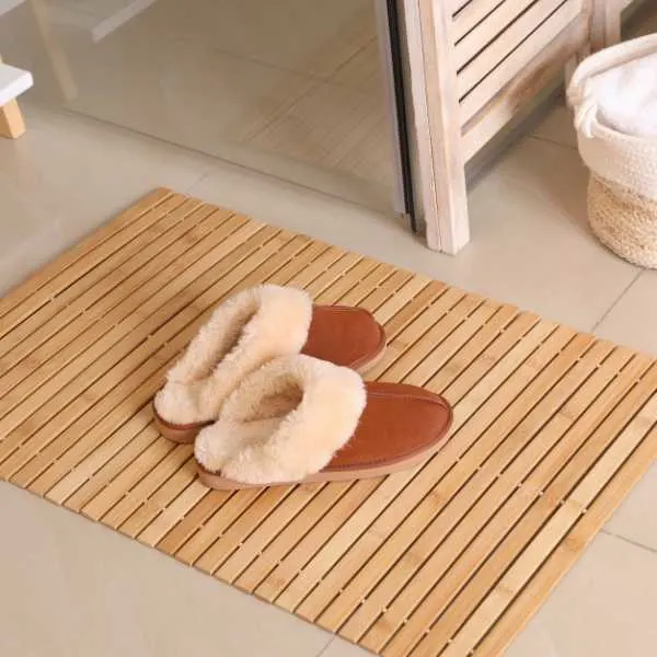 Wooden mat and slippers on bathroom floor.