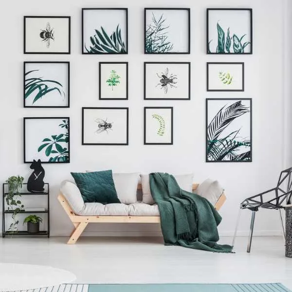 Green and white living room with photo gallery and couch.