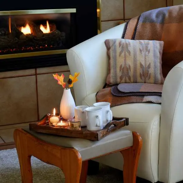 Chair and foot stool near a fireplace/
