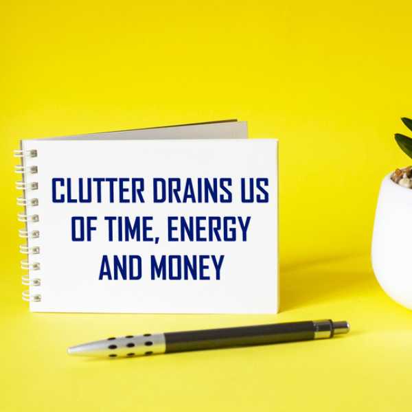 Clutter drains us of time, energy and money text on a note pad against a yellow background.