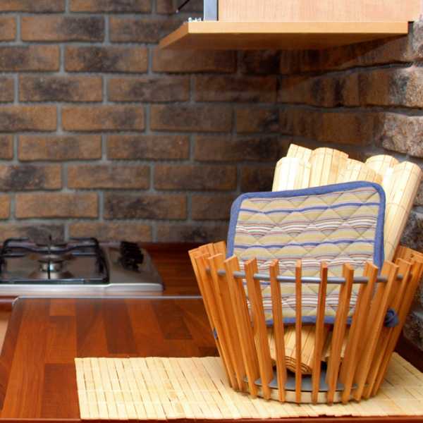 Old wooden basket filled with items on kitchen counter.