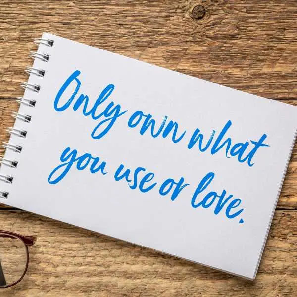 Only own what you use or love text on a notepad.