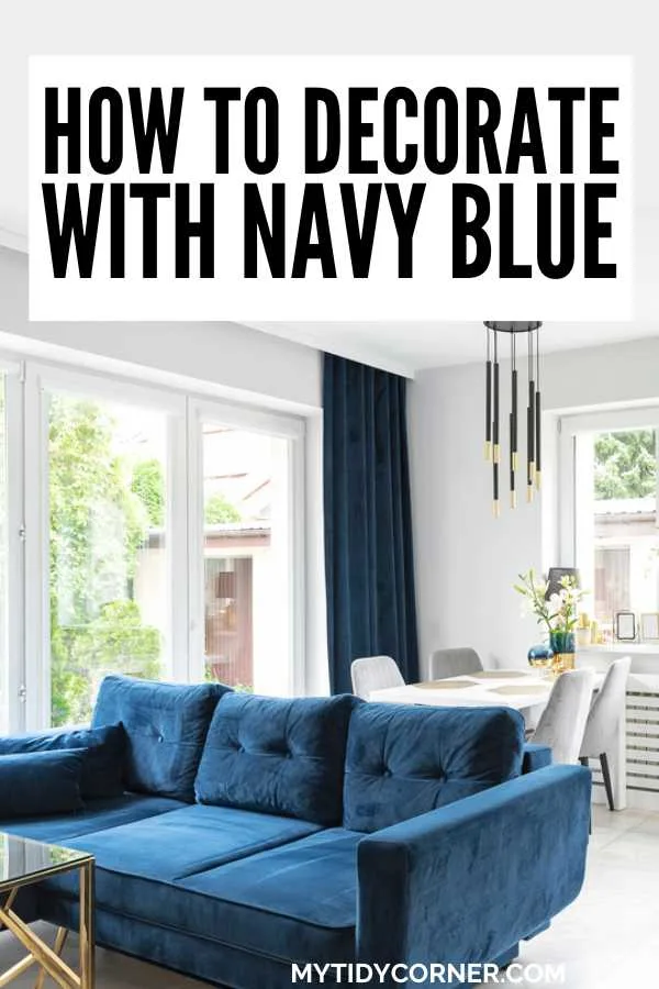 Living room with deep blue sofa and curtain and text overlay that reads, "How to decorate with navy blue".