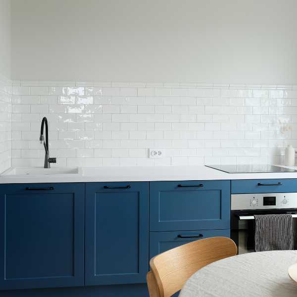 White kitchen with navy blue cabinets.