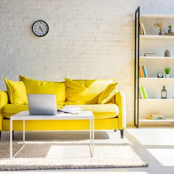 Yellow couch in a sunlit room.