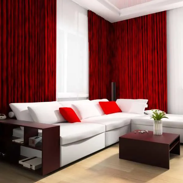 Luxury living room with red curtains, light wood floor, white couch, red throw pillows, and brown coffee table and side table.