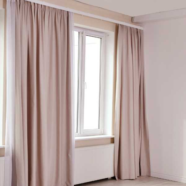 Room with blush curtains and white walls.