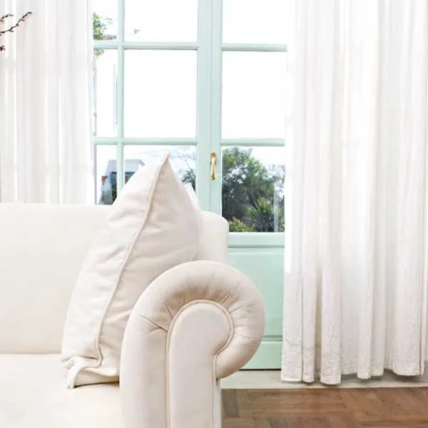 Room with white curtains and couch.