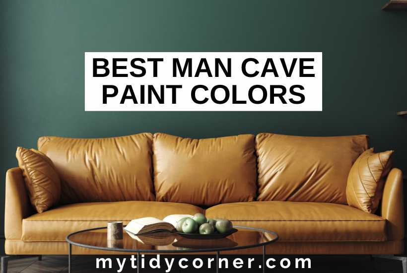 Book and fruit on a coffee table, light brown couch, green wall background and text overlay that says, "Best man cave paint colors".