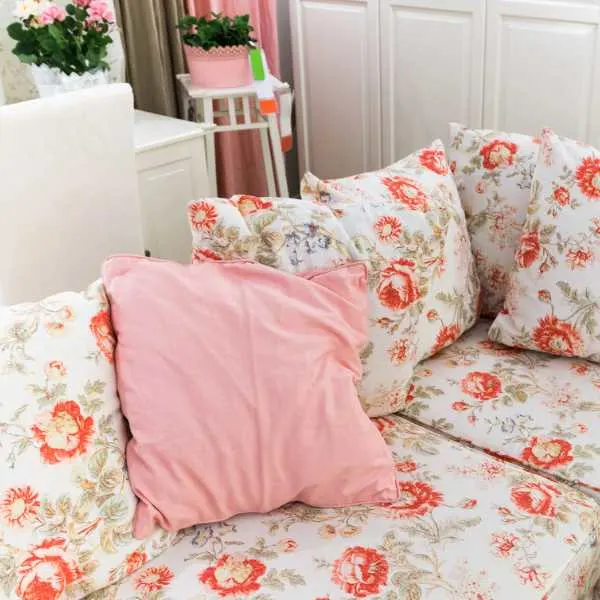 Room with floral couch and throw pillows.