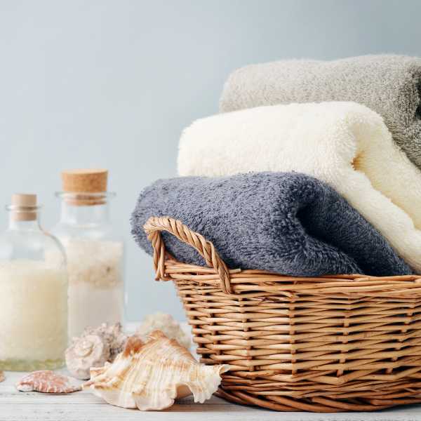 Bath products and towels in a basket.