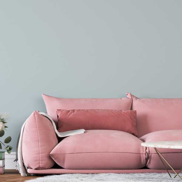 Blush pink couch bluish gray wall.