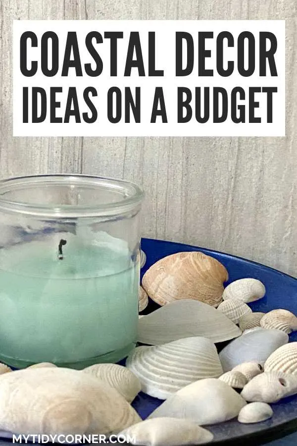 Looking to refresh your home with coastal charm? Bring the beauty of the seaside indoors with our top coastal decor ideas. Transform your home into a serene beach retreat with these coastal decorating ideas! Check out these gorgeous beach decor ideas to infuse your space with ocean-inspired elegance. Candle in a glass jar, sea shells on a blue tray and text overlay that says, "Coastal decor ideas on a budget".