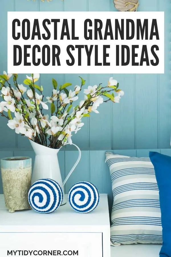 Flowers in a white vase on white table, blue and white throw pillows on a blue couch and text overlay that says, "Coastal grandma decor style ideas".