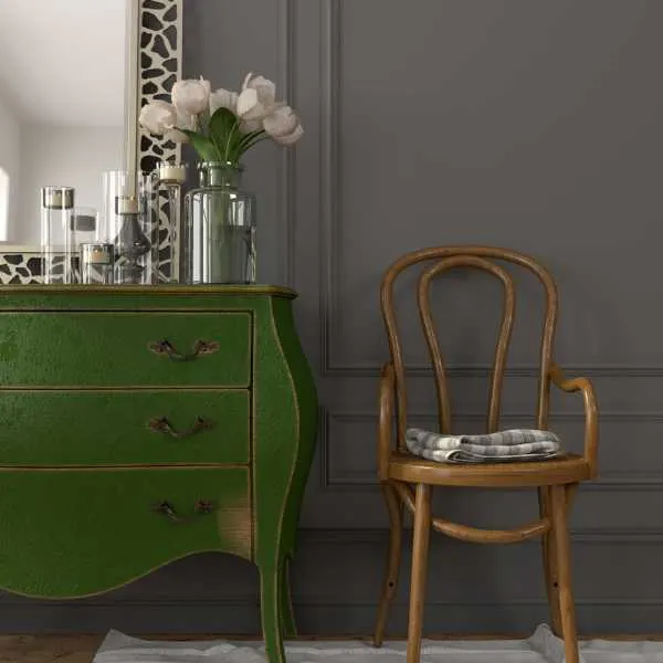 Green dresser and chair against gray wall.