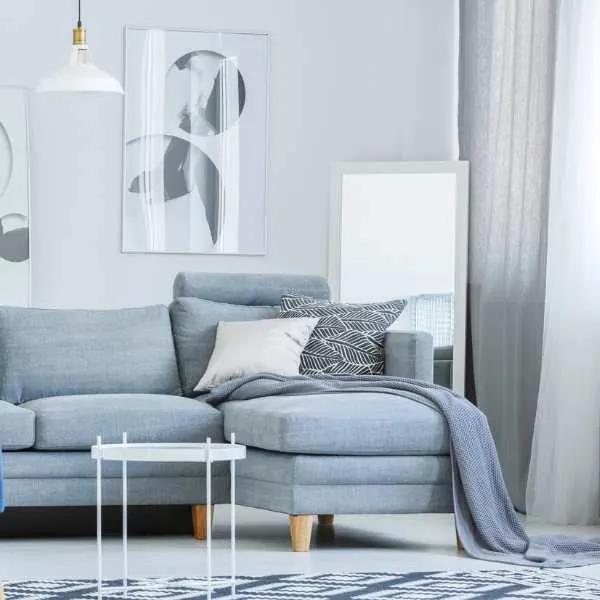 Powder blue couch gray curtain and wall.