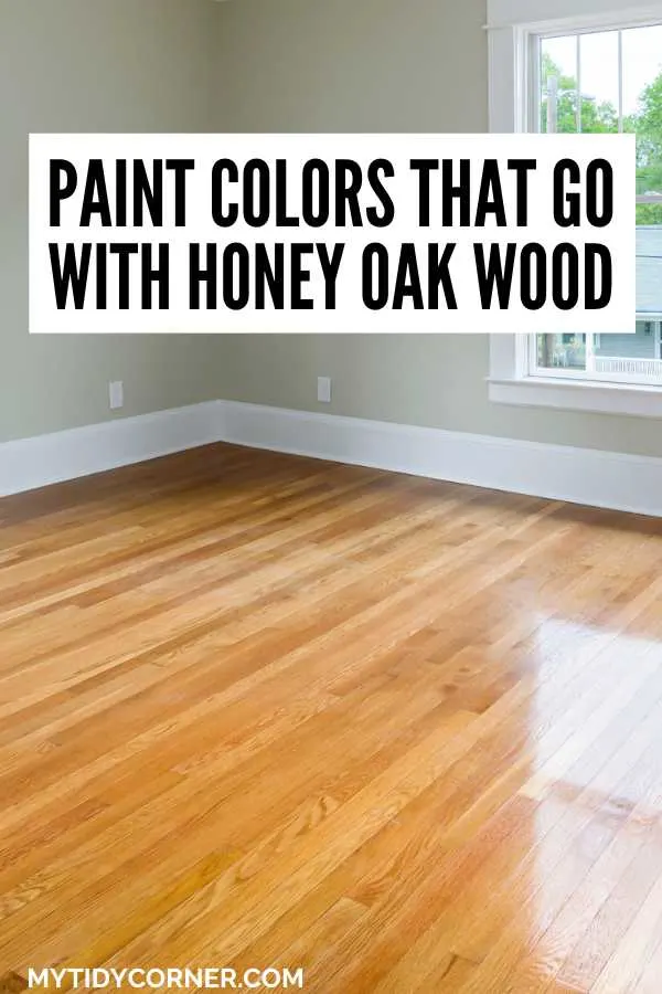 Room with wood floor and gray wall text overlay that says, "Paint colors that go with honey oak wood".