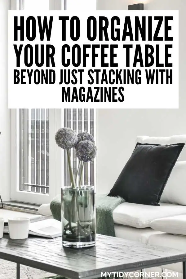 Faux flower on a coffee table, couch and text overlay that says, "How to organize your coffee table beyond just stacking with magazines".