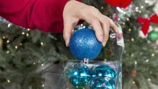 A woman putting away Christmas ornaments - Featured image for 